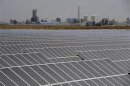 A solar power plant is seen near a thermal power plant in Aksu