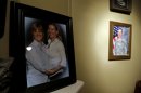 In this photo taken Wednesday, March 20, 2013 in Raeford, N.C., Tracy Dice Johnson and her wife, Sgt. Donna Johnson, are shown in a portrait, while Donna's military portrait hangs at rear. When Donna Johnson was killed in Afghanistan last year, Dice, a North Carolina National Guardswoman, heard about it from her sister-in-law. Although Donna Johnson had listed Dice as her next-of-kin, Army casualty officers informed Johnson's mother of her death first because of a federal law that prohibits the U.S. government from recognizing same-sex unions. (AP Photo/Gerry Broome)
