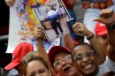 Supporters of Venezuela's President Hugo Chavez hold up a photo of him at an event commemorating the 1958 fall of the country's dictatorship in Caracas, Venezuela, Wednesday, Jan. 23, 2013. Chavez, who was re-elected to another six-year term in October, has not appeared or spoken publicly since he left for Havana on Dec. 10. Government officials have said the 58-year-old president is improving after suffering complications including a severe respiratory infection, but they have not provided specific details about his health. (AP Photo/Fernando Llano)