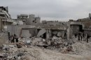 Syrian citizens inspect the desolated site of a government airstrike in Aleppo on March 19.