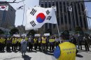 South Korean members of the Abductees Family Association with their national flags hold an anti-North Korea rally in Seoul, South Korea, Sunday, April 14, 2013. As the world watches to see what North Korea's next move will be in a high-stakes game of brinksmanship with the United States, residents of its capital aren't hunkering down in bunkers and preparing for the worst. Instead, they are out on the streets en masse getting ready for the birthday of national founder Kim Il Sung - the biggest holiday of the year. (AP Photo/Kin Cheung)