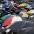 FILE - In this July 8, 2012 file photo, spectators take cover under umbrellas as they gather ahead of Andy Murray of Britain facing Roger Federer of Switzerland during the men's singles final match at the All England Lawn Tennis Championships at Wimbledon, England. Gold, silver, bronze: No matter who wins what at the London Olympics, a million or more visitors will need to get themselves an umbrella. (AP Photo/Alastair Grant, File)