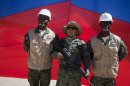 Members of Haiti's new national military force pose for a picture with an Ecuadorean soldier, center, during a ceremony in the farming village of Petite Rivere de L'Aritibonite, Haiti, Monday, Sept. 16, 2013. Haiti moved closer on Monday to reconstituting a military that was abolished in 1995, in a small ceremony welcoming the first 41 recruits who recently returned from eight months of training in Ecuador. They will be the first members of a national military force that the government of President Michel Martelly wants to revive. (AP Photo/Dieu Nalio Chery)