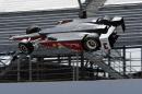 The car driven by Helio Castroneves, of Brazil, is airborne after hitting the wall in the first turn during practice for the Indianapolis 500 auto race at Indianapolis Motor Speedway in Indianapolis, Wednesday, May 13, 2015. (AP Photo/Joe Watts)