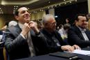Greek PM Tsipras adjusts his shirt collar as he sits next to Deputy Prime Minister Dragasakis and Digital Policy Minister Pappas before his speech at the ruling Syriza party central committee in Athens
