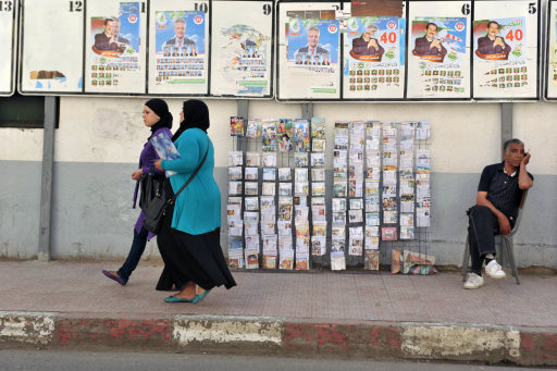 A street vendor is seated under electoral posters in Algiers, Algeria, Tuesday May 8, 2012. The legislative elections will take place in Algeria on May 10. Islamists will square off against pro-government parties in what many expect to be the freest elections in Algeria since 1991.(AP Photo/Ouahab Hebbat)