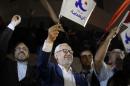 Rached Ghannouchi, leader of the Islamist party Ennahda, waves the party flag outside Ennahda's headquarters in Tunis