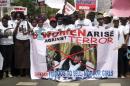 People carry a banner with an image of Boko Haram leader?Abubakar?Shekau?as they protest for the release of the abducted secondary school girls in the remote village of Chibok, along a road in Lagos