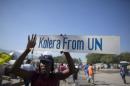 A protester holds up a sign during a demonstration against the UN mission in downtown Port-au-Prince