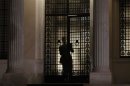 An official closes the door of the office of Greece's Prime Minister Samaras after government ministers arrived for a snap cabinet meeting in Athens