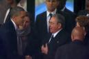 In this image from TV, U.S. President Barack Obama shakes hands with Cuban President Raul Castro at the FNB Stadium in Soweto, South Africa, in the rain for a memorial service for former South African President Nelson Mandela, Tuesday Dec. 10, 2013. The handshake between the leaders of the two Cold War enemies came during a ceremony that's focused on Mandela's legacy of reconciliation. Hundreds of foreign dignitaries and world heads of states gather Tuesday with thousands of South African people to celebrate the life, and mark the death, of Nelson Mandela who has became a global symbol of reconciliation. (AP Photo/SABC Pool)