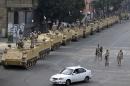 In this Friday, Aug. 16, 2013 photo, Egyptian army soldiers take their positions on top and next to their armored vehicles to guard an entrance of Tahrir square, in Cairo, Egypt. Egypt's capital has long been proud of its nickname, 