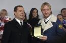 Russia's Prime Minister Medvedev and figure skating gold medal winner Plushenko attend ceremony to present automobiles to the Sochi 2014 Winter Olympics prize-holders representing Russia, by the Kremlin wall in central Moscow