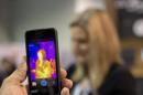 The FLIR ONE thermal imager for the iPhone is demonstrated at the International Consumer Electronics Show, Thursday, Jan. 9, 2014, in Las Vegas. The imager attaches to the back of an iPhone 5 or 5s and translates heat data into color images on the phone's screen. (AP Photo/Julie Jacobson)
