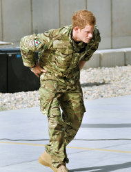 Britain's Prince Harry examines the 30mm cannon of an Apache helicopter Friday Sept 7 2012 at Camp Bastion in Afghanistan, where he will be operating from during his tour of duty as a co-pilot gunner. The Prince has returned to Afghanistan to fly attack helicopters in the fight against the Taliban. (AP Photo/ John Stillwell, Pool)