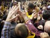 Minnesota's Rodney Williams Jr., center, is surrounded by fans as he leaves the court after defeating Indiana 77-73 in an NCAA college basketball game, Tuesday, Feb. 26, 2013, in Minneapolis. (AP Photo/Tom Olmscheid)