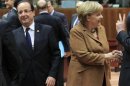 France's President Hollande walks past Germany's Chancellor Merkel during European Union leaders summit in Brussels