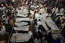 Pakistani relatives gather around the bodies of blast victims after a suicide bomb attack near the Wagah border on November 2, 2014