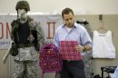 Rick Brand, Chief Operating Officer of Amendment II, holds a children's backpack, left, and anti-ballistic insert at the company's manufacturing facility in Salt Lake City, Wednesday, Dec. 19, 2012. Anxious parents reeling in the wake the Connecticut school shooting are fueling sales of armored backpacks for children emblazoned with Disney and Avengers logos, as firearms enthusiasts stock up on assault rifles nationwide amid fears of imminent gun control measures. At Amendment II, sales of childrenís backpacks and armored inserts are up 300 percent. (AP Photo/Rick Bowmer)