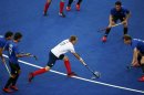Britain's Daniel Fox dribbles surrounded by Argentina's players during their men's Group A hockey match at the London 2012 Olympic Games