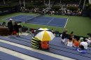 Spectators wait out a rain delay on Court 7 during the 2013 U.S. Open tennis tournament, Wednesday, Aug. 28, 2013, in New York. (AP Photo/Mike Groll)