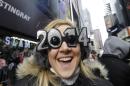 FILE - This Dec. 31, 2013, file photo shows Veronica Boshen of Allentown, PA., in her 2014 glasses while waiting for the ball drop celebration to begin in Times Square on New Year's Eve, in New York. Americans are closing out 2014 on an optimistic note, according to a new Associated Press-Times Square Alliance poll. Nearly half predict that 2015 will be a better year for them than 2014 was, while only 1 in 10 think it will be worse. There's room for improvement: Americans give the year gone by a resounding 'meh.' (AP Photo/Kathy Willens, File)