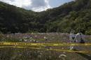 Forensic examiners stand atop a garbage-strewn hillside where authorities are searching for human remains in the densely forested mountains outside Cocula, in Guerrero state, Mexico, Tuesday, Oct. 28, 2014. Suspects arrested this week told prosecutors that many of the 43 students who disappeared Sept. 26 from Iguala had been held near this location. (AP Photo/Rebecca Blackwell, Pool)