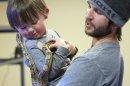 Thomas Cobb lets his young son Daiden hold one of his snakes as he shows off several of his exotic reptile that he keeps in a special basement room of his home, Friday, April 26, 2013 in Cottonwood Heights, Utah. Cobb has been ordered by police to get rid of all but one of his 29 exotic boa constrictor snakes because he doesn't have an exotic pet permit. (AP Photo/The Deseret News, Scott G. Winterton) SALT LAKE TRIBUNE OUT; MAGS OUT