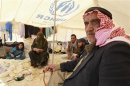 Syrian refugees sit in second hand clothes shop at Al Zaatri refugee camp in Mafraq
