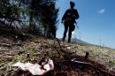 A member of the state police stands by a bloodstain during a search for evidence along the Jalisco-Michoacan highway in Tanhuato, Michoacan State on May 23, 2015