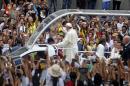 Pope Francis waves to well-wishers aboard the popemobile near the Manila Cathedral