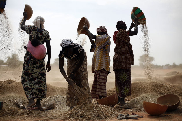 Malian women sift wheat in a field near  Segou, central Mali, some 240kms (140 miles) from Bamako Tuesday, Jan. 22, 2013.  French troops in armored personnel carriers rolled through the streets of Dia