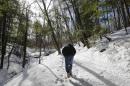 Randy Patten walks along a path in a ravine on Wednesday, Feb. 26, 2014, in Lake George, N.Y. In the 1990s, businessman Anthony Tomasovic was granted permission to fill in his vacant, sloping property bordering the ravine where British Colonial troops and their Mohawk Indian allies were ambushed by a larger force of French and Indians in 1755. The land borders the wooded ravine where about 1,000 British Colonial troops and 200 of their Mohawk Indian allies were ambushed by a larger force of French and Indians on the morning of Sept. 8, 1755. Patten is convinced many of the scores of casualties from the ambush were buried afterward in the ravine. (AP Photo/Mike Groll)