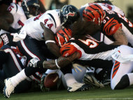 El running back Ben Tate (44) de los Texans de Houston pierde la pelota al ser golpeado por los linebackers Rey Maualuga (58) and Dan Skuta (51) de los Bengals de Cincinnati en la primera mitad del partido de la NFL el domingo 11 de diciembre del 2011 en Cincinnati. (Foto AP/Tony Tribble)