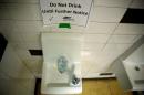 A sign which reads ' Don Not Drink Until Further Notices' next to a water dispenser at North Western high school in Flint, a city struggling with the effects of lead-poisoned drinking water, in Michigan
