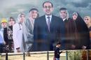 An Iraqi man walks past a huge election poster for Prime Minister Nuri al-Maliki on display in Baghdad, on March 25, 2014