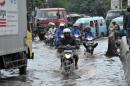 Vehicles drive on a flooded road in Jakarta on January 17, 2014