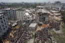 Crowds gather at the collapsed Rana Plaza building as people rescue garment workers trapped in the rubble, in Savar