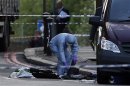 A police forensics officer investigates a crime scene where one man was killed in Woolwich, southeast London
