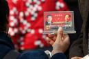 A street vendor displays a souvenir with pictures of Chinese President Xi and late Chinese Chairman Mao to visitors in Beijing