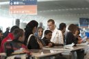 Roma's who are part of a voluntary repatriation scheme stand at check-in desk at Roissy Charles-de-Gaulle airport