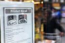 A customer enters an Aldi supermarket displaying a recall sign for products where horsemeat was detected, in northwest London
