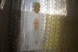 A poster depicting Pope Francis is covered by a curtain …