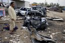 An Iraqi man inspects the aftermath of a car bomb attack at a used cars dealers parking lot in Habibiya neighborhood of eastern Baghdad, Iraq, Tuesday, April 16, 2013. Less than a week before Iraqis in much of the country are scheduled to vote in the country's first elections since the 2011 U.S. troop withdrawal, a series of attacks across Iraq on Monday, many involving car bombs, has killed and wounded dozens of people, police said. (AP Photo/ Karim Kadim)