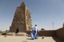 A man stands in front of the Djingareyber mosque on February 4, 2016 in Timbuktu