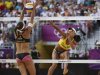 Brazil's Juliana spikes the ball as Germany's Ilka Semmler blocks it during their women's preliminary round beach volleyball match at the London 2012 Olympic Games at Horse Guards Parade