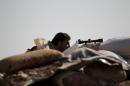 A Free Syrian Army fighter of the 101 Division takes a position behind sandbags near the town of Morek in the northern countryside of Hama, Syria