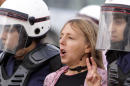 FILE - In this Friday, Feb. 17, 2012 file photo, riot police arrest U.S. activist Medea Benjamin during a protest march by Bahraini women in Qadam, Bahrain. The co-founder of U.S.-based anti-war group Code Pink says Egyptian police detained her at the airport Tuesday, March 4, 2014 when she tried to enter the country and assaulted her, fracturing her shoulder, as they handcuffed her before deporting her. Benjamin says she was detained for hours at the airport upon arrival on route to the Gaza Strip as part of an international women's delegation. (AP Photo/Hasan Jamali, File)