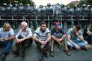 Protesters sit on a street in front of riot police during a protest against an increase of electricity prices in Yerevan on June 26, 2015