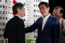 Japan's Prime Minister Shinzo Abe, who is also leader of the ruling Liberal Democratic Party (LDP), smiles as he puts a rosette on the name of a candidate who is expected to win the upper house election, at the LDP headquarters in Tokyo, Japan
